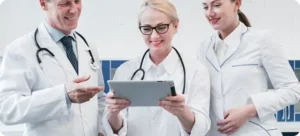 Doctors reviewing patient data and medical reports using a tablet
